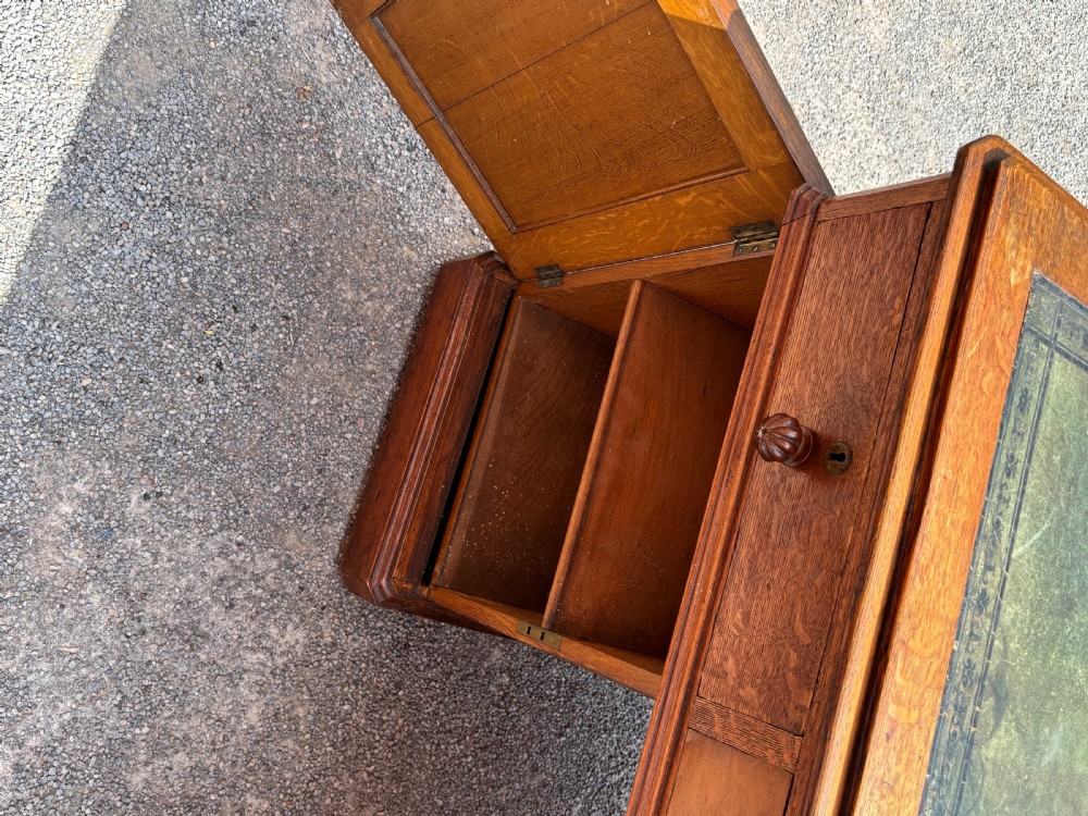 A 19th-century oak partners desk featuring a green leather inset top, two pedestals with multiple drawers, and carved wooden handles. View VII
