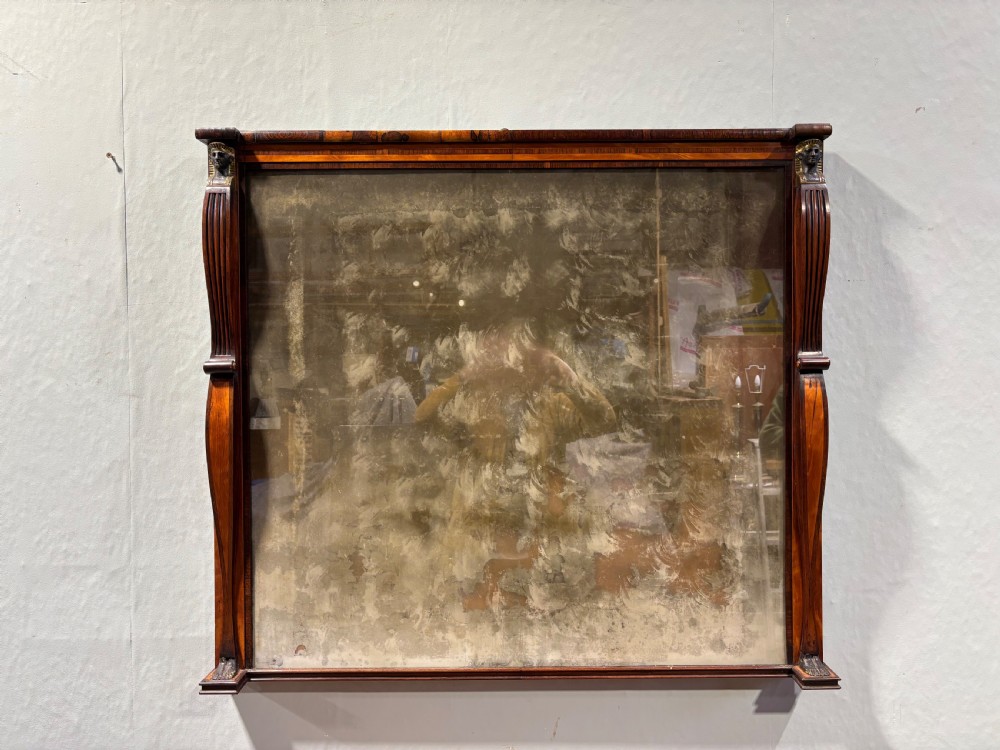 An early 19th-century Regency Egyptian Revival rosewood side cabinet with bow front, brass trellis doors, and a matching overmantel wall mirror. View XVII