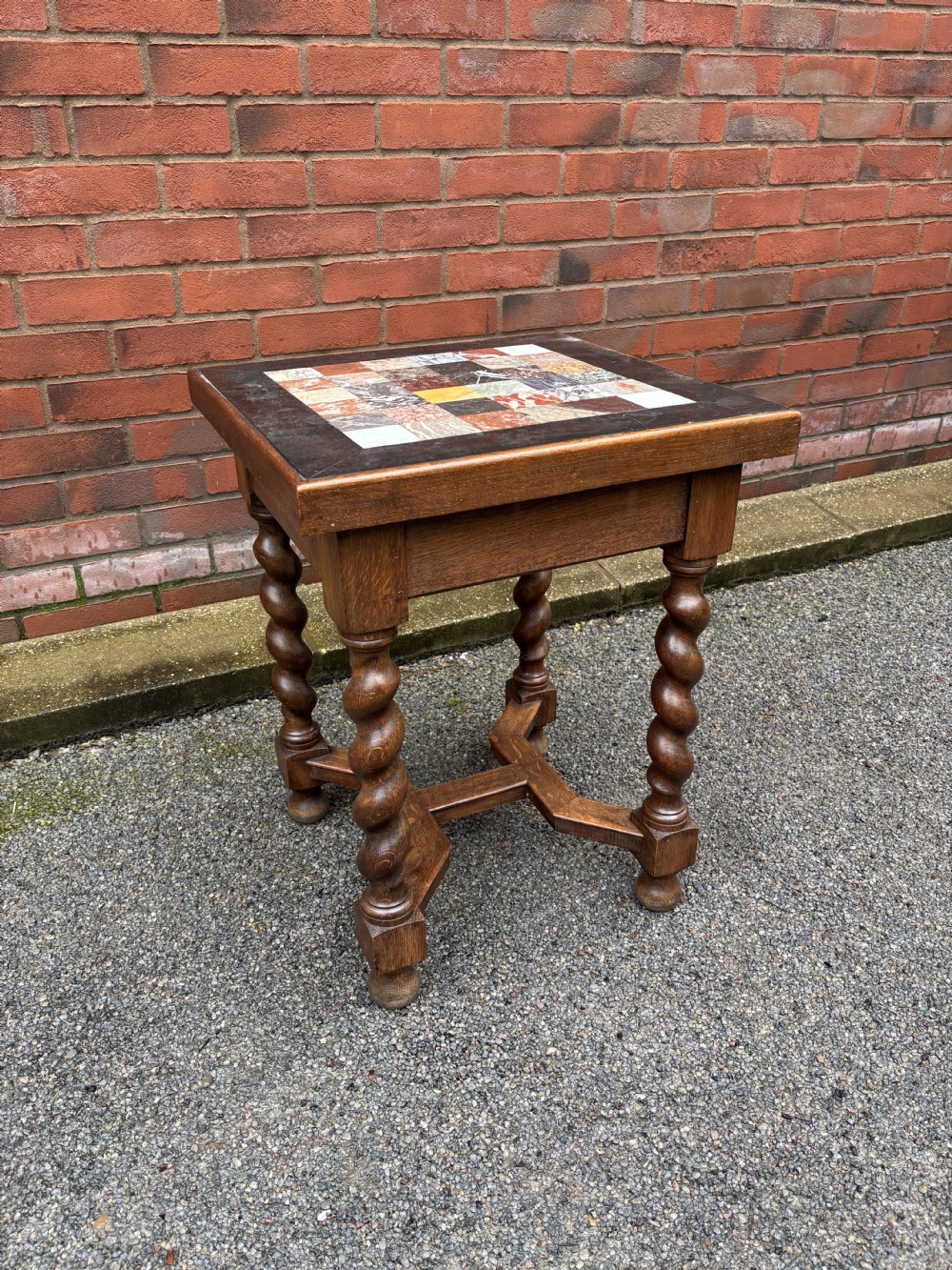 A 19th-century oak side table featuring a chequered specimen marble inset top supported by four barley twist legs and joined stretchers.