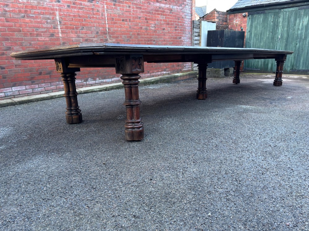 An 18-foot long 19th-century Gothic Revival solid oak table featuring carved clustered column legs and a plank top. View VI