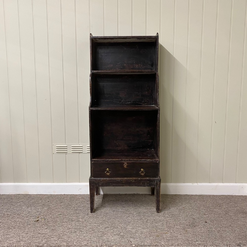 A tall, narrow dark brown Regency waterfall bookcase featuring open graduated shelves above a single drawer with brass drop handles.