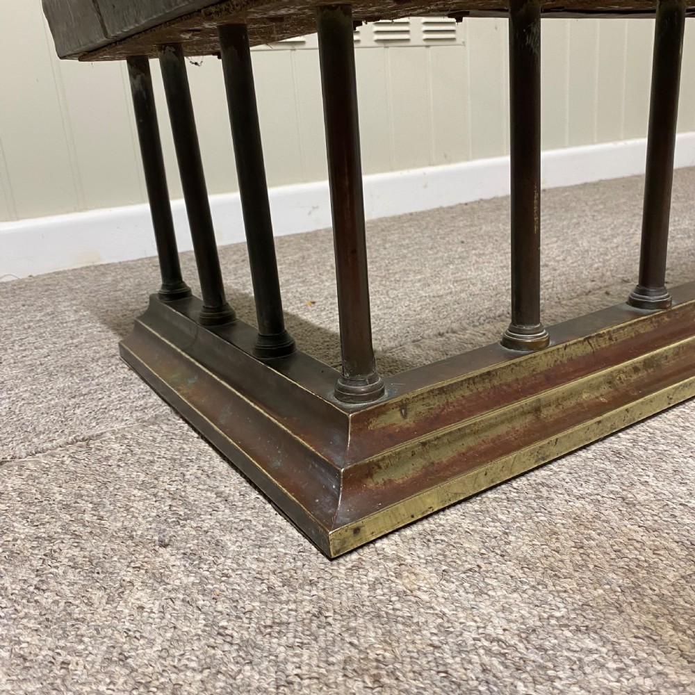 A Victorian club fender featuring a dark brown leather upholstered seat rail supported by turned wooden spindles on a polished wood and brass base. View II