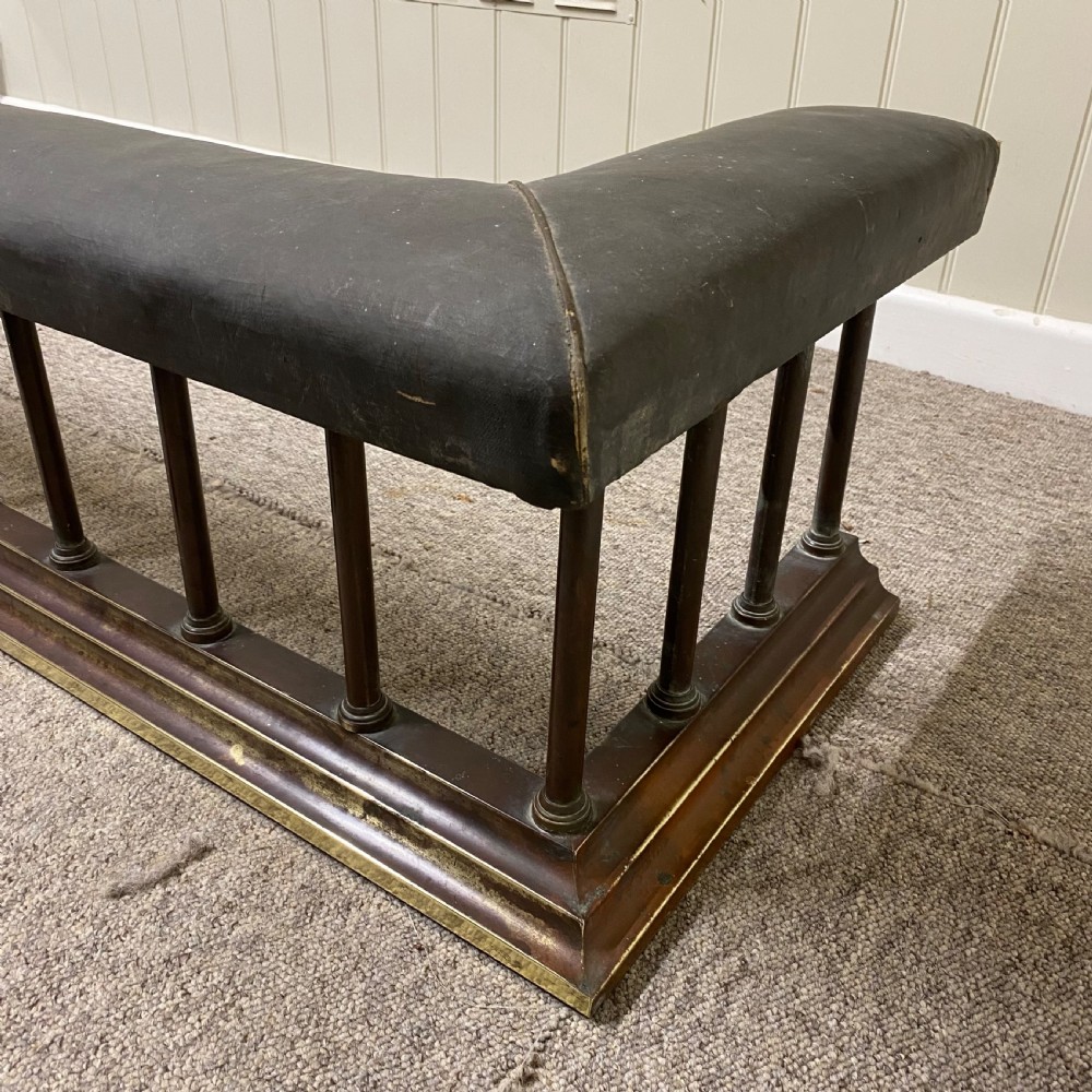 A Victorian club fender featuring a dark brown leather upholstered seat rail supported by turned wooden spindles on a polished wood and brass base. View III