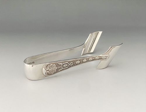 fig 1. A pair of sterling silver individual asparagus tongs featuring chased shell and foliage relief work along the handles.