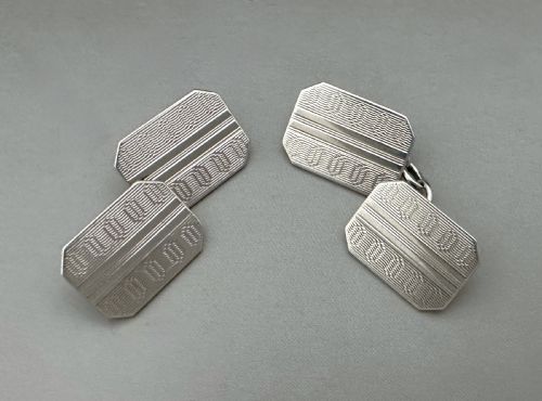 fig 1. A pair of mid-20th-century silver double-sided cufflinks with engine-turned wavy patterns and octagonal faces connected by chain links.