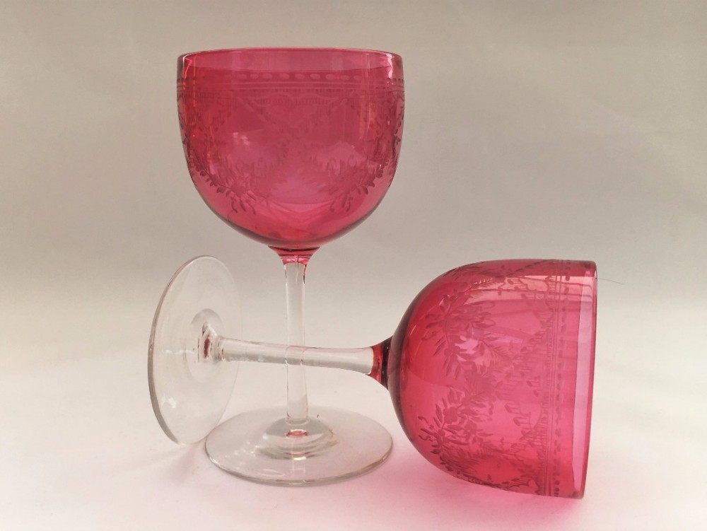 A lovely pair of victorian cranberry bowl engraved wine glasses