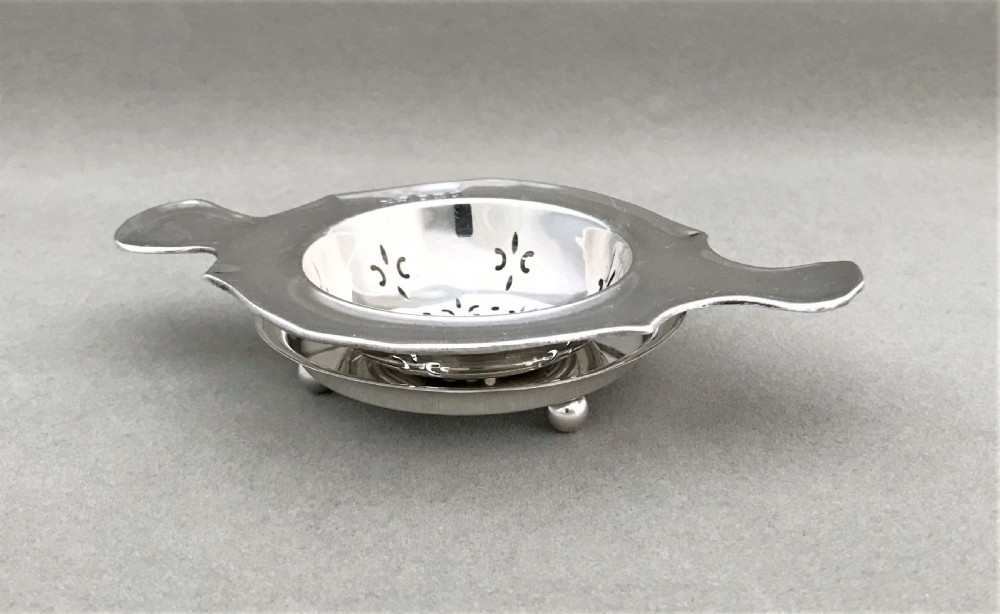 A gorgeous silver tea strainer and drip stand View II