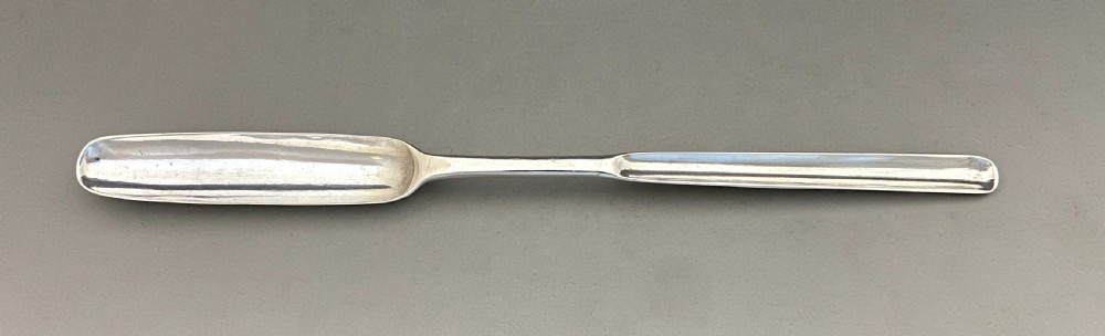 A long, slender George II sterling silver marrow scoop featuring a wide channelled scoop at one end and a narrower trough at the opposite end. View II