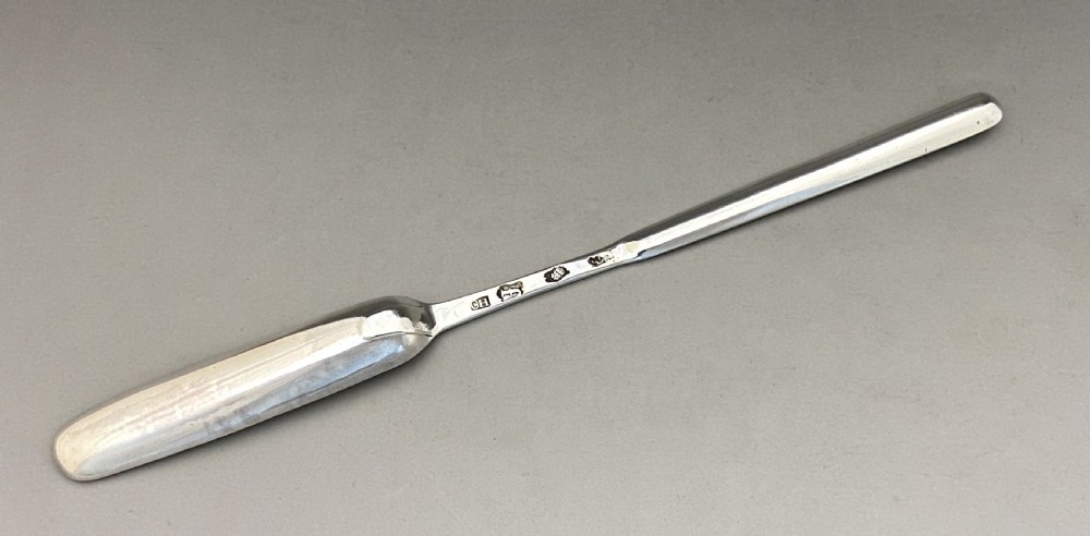 A long, slender George II sterling silver marrow scoop featuring a wide channelled scoop at one end and a narrower trough at the opposite end. View III