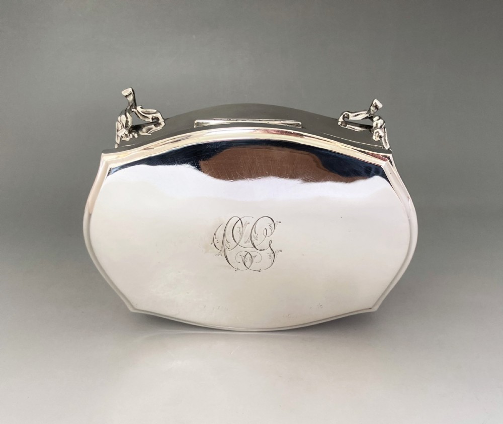 An octagonal silver trinket box with four cabriole legs, an engraved monogram on the top, and stamped hallmarks on the side. View VII