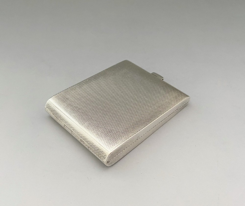An Art Deco rectangular silver matchbook case featuring engine-turned crosshatch texturing and geometric stepped motifs in opposite corners. View III