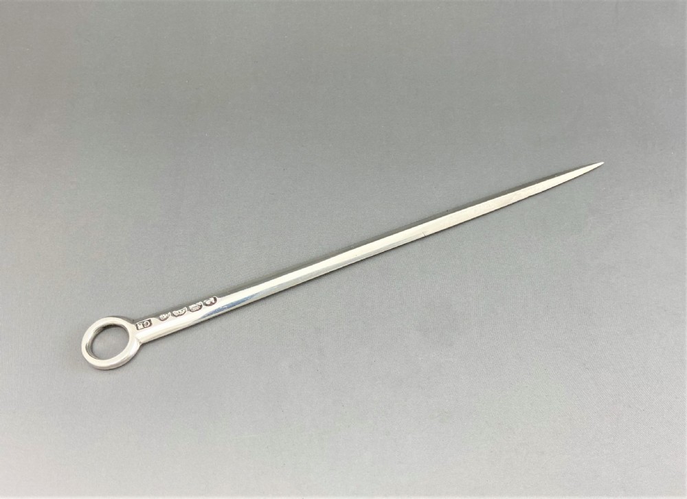 A tapered Georgian sterling silver game skewer featuring a smooth ring handle and stamped hallmarks near the top. View III