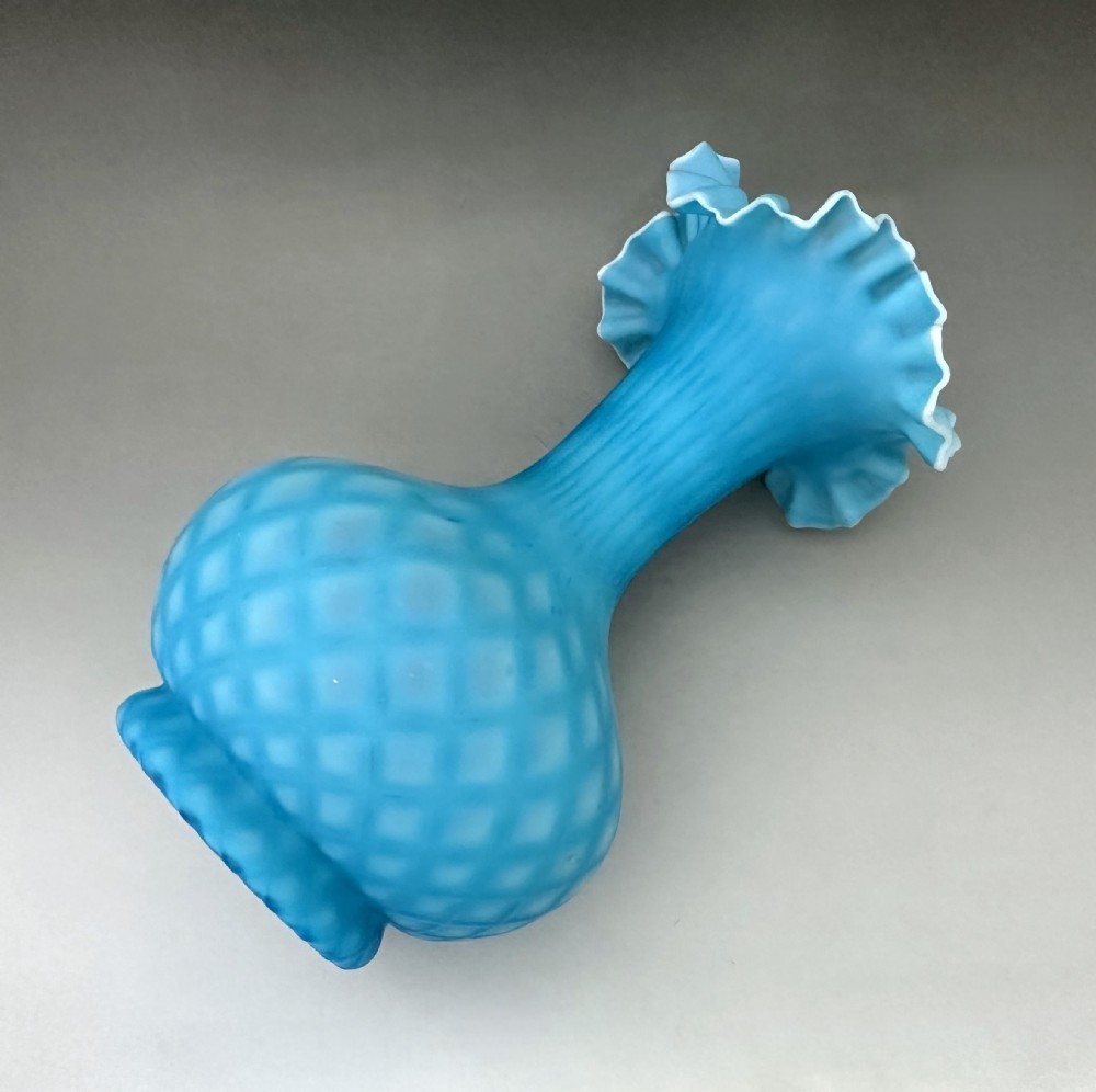A light blue Victorian satin glass vase featuring a diamond air-trap pattern, a bulbous body, and a flared crimped rim with white cased glass detail. View V