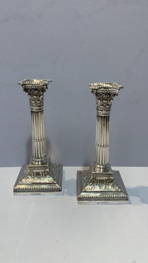 AN ANTIQUE PAIR OF SILVER CANDLESTICKS