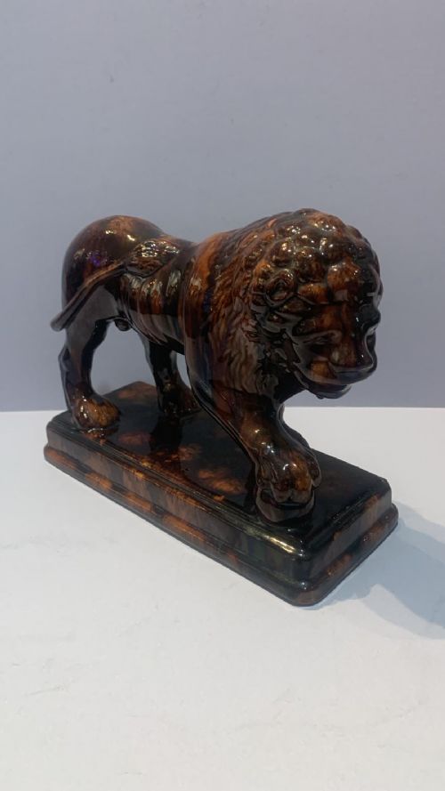 AN ANTUQUE TREACLE GLAZED LION