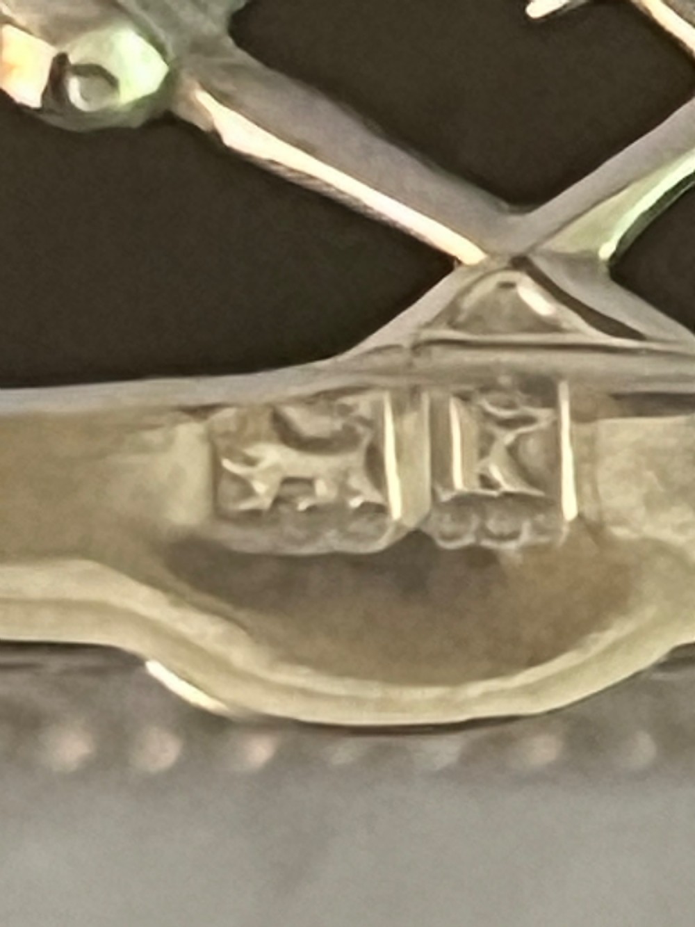 A small silver basket featuring double hinged pierced lids, a central rope-twist handle, and a diaper-patterned body with floral motifs. View VI