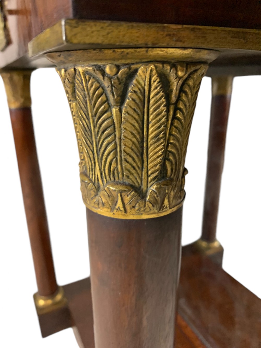 A French Empire mahogany console table featuring a grey marble top, gilt bronze column capitals, a central figural frieze mount, and a mirrored back plate. View V