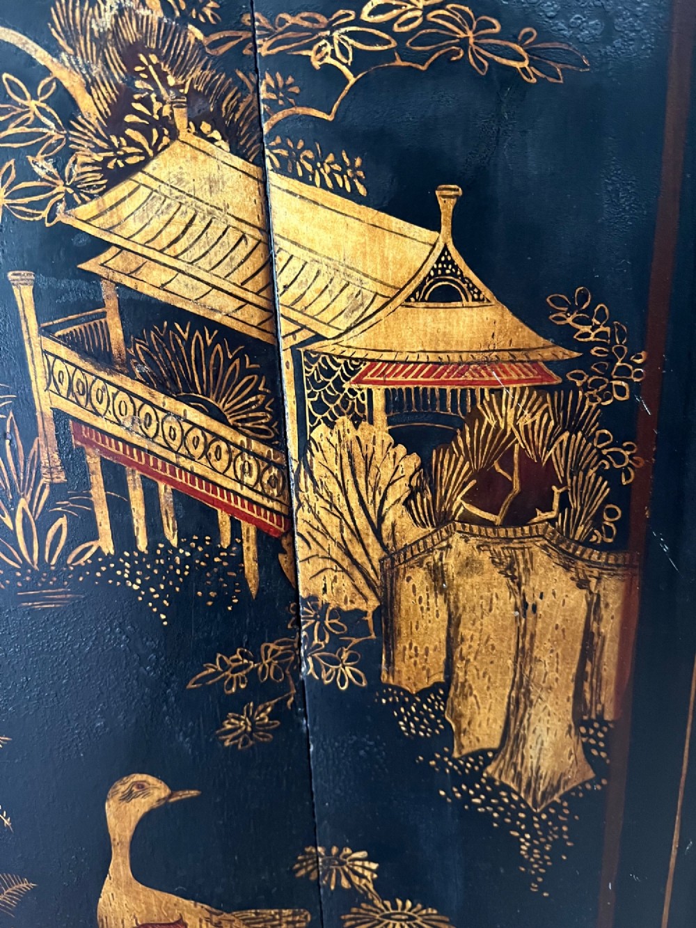 A dark black japanned hanging corner cabinet featuring gilt chinoiserie artwork with birds, architectural pagodas, and brass hinges. View VII