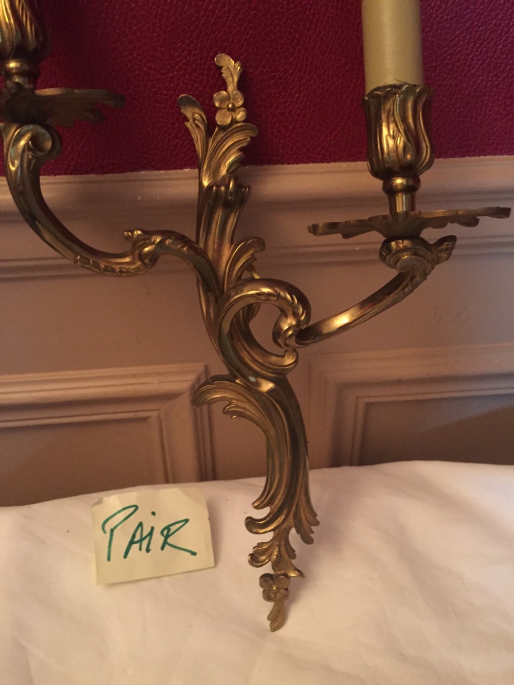A pair of cast bronze twin-arm Art Nouveau wall lights featuring foliate scrollwork and candle sleeve fittings. View VII
