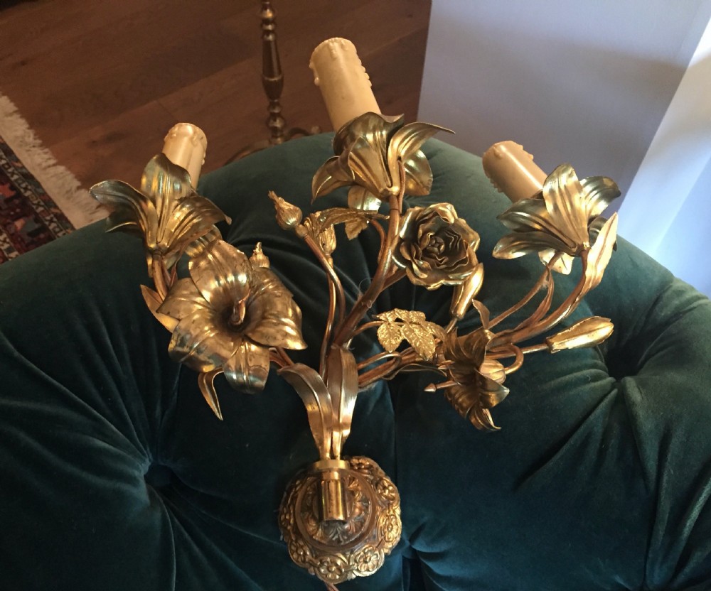 A pair of Art Nouveau gilt metal wall lights featuring three branches decorated with sculpted roses, lilies, and leaves holding candle-effect sockets. View VII