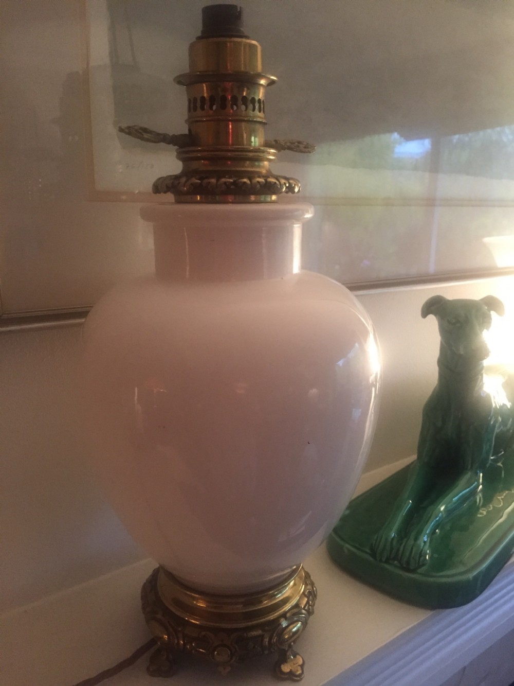 A white glazed faience urn-form table lamp base featuring ornate cast brass mounts at the top and footed base. View VI