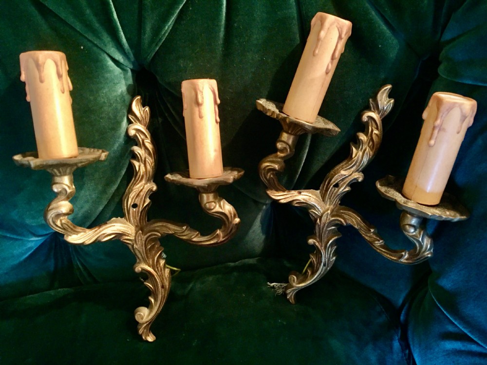 A pair of nineteenth-century French cast bronze two-arm wall sconces decorated with ornate leaf scrollwork and candle-effect sleeves. View III