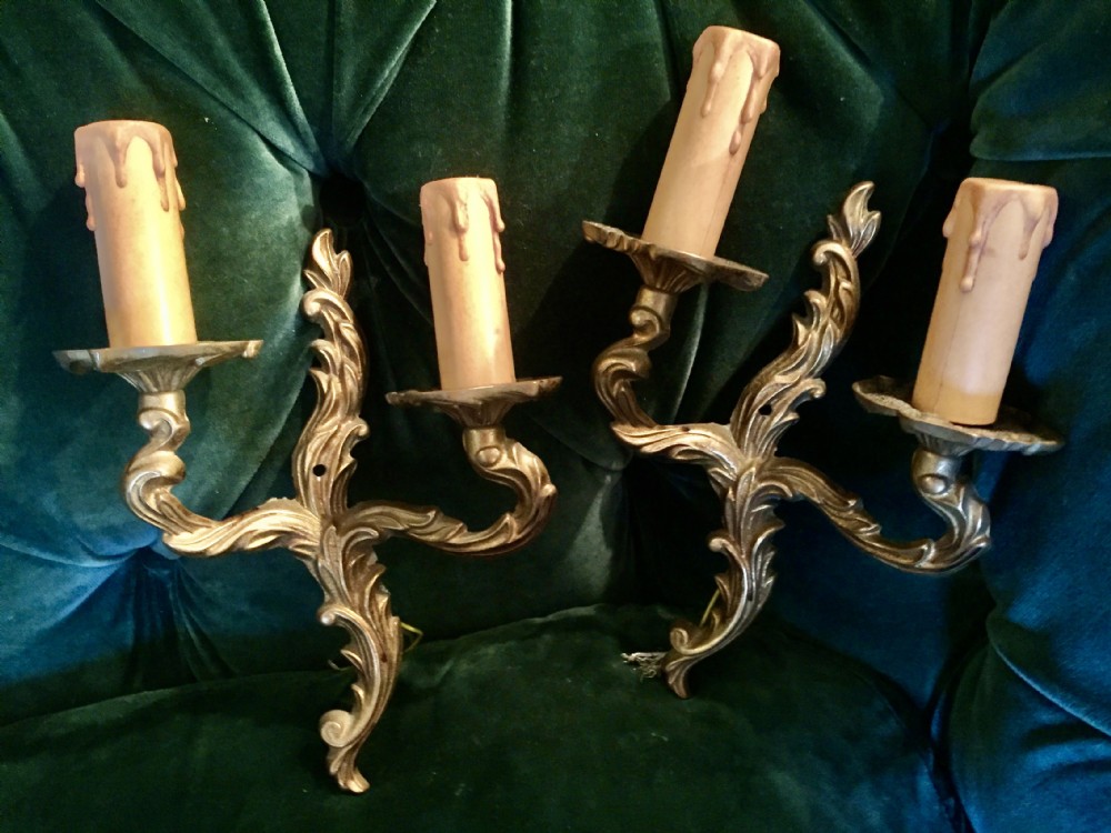 A pair of nineteenth-century French cast bronze two-arm wall sconces decorated with ornate leaf scrollwork and candle-effect sleeves. View IV