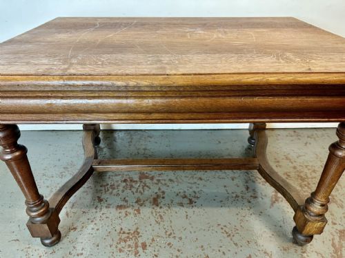 fig 1. An antique French oak dining table featuring turned baluster legs, a moulded apron, and a low stretcher base.