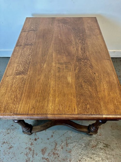 fig 2. An antique French oak dining table featuring turned baluster legs, a moulded apron, and a low stretcher base.
