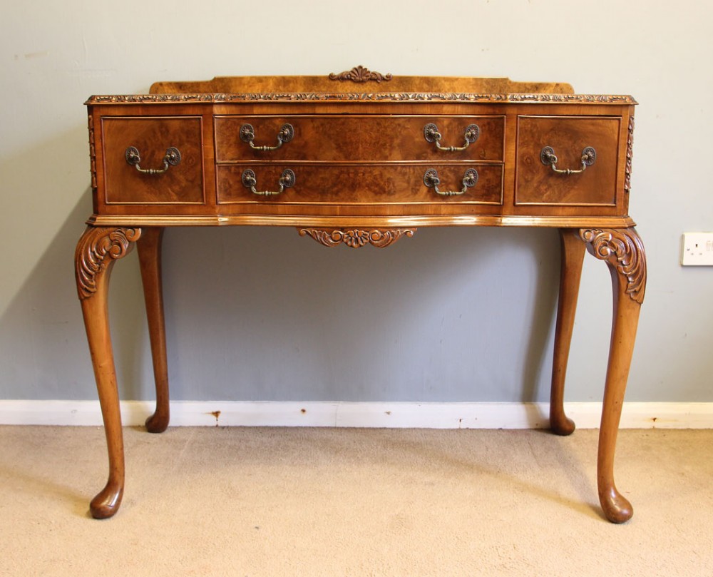 An antique burr walnut server side table featuring carved cabriole legs, brass drop handles, and a carved back gallery. View II