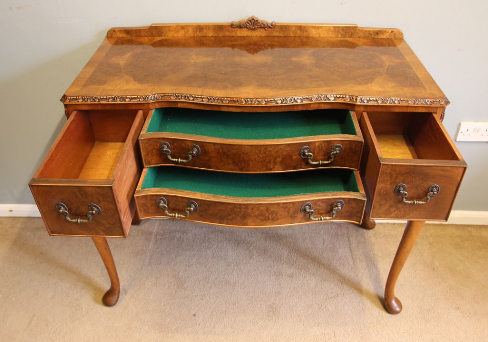 An antique burr walnut server side table featuring carved cabriole legs, brass drop handles, and a carved back gallery. View VI
