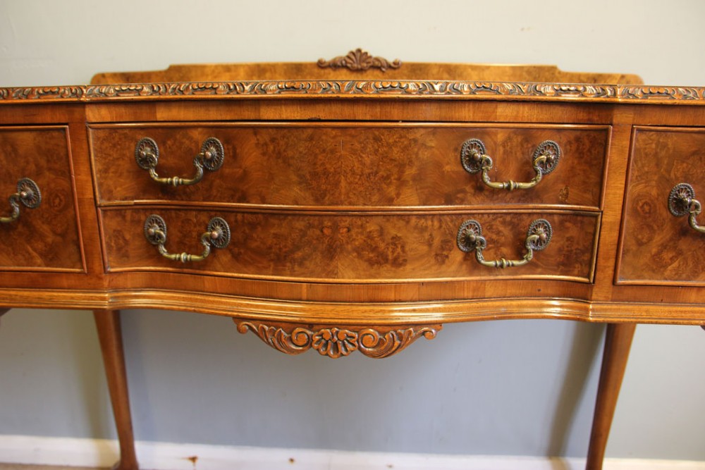 An antique burr walnut server side table featuring carved cabriole legs, brass drop handles, and a carved back gallery. View X