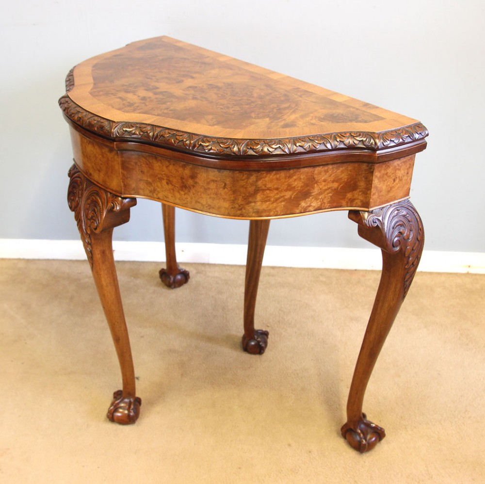 A demi-lune burr walnut fold-over card table featuring carved edges, cabriole legs, and carved ball-and-claw feet. View VIII