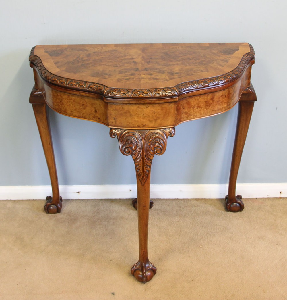 A demi-lune burr walnut fold-over card table featuring carved edges, cabriole legs, and carved ball-and-claw feet. View XI