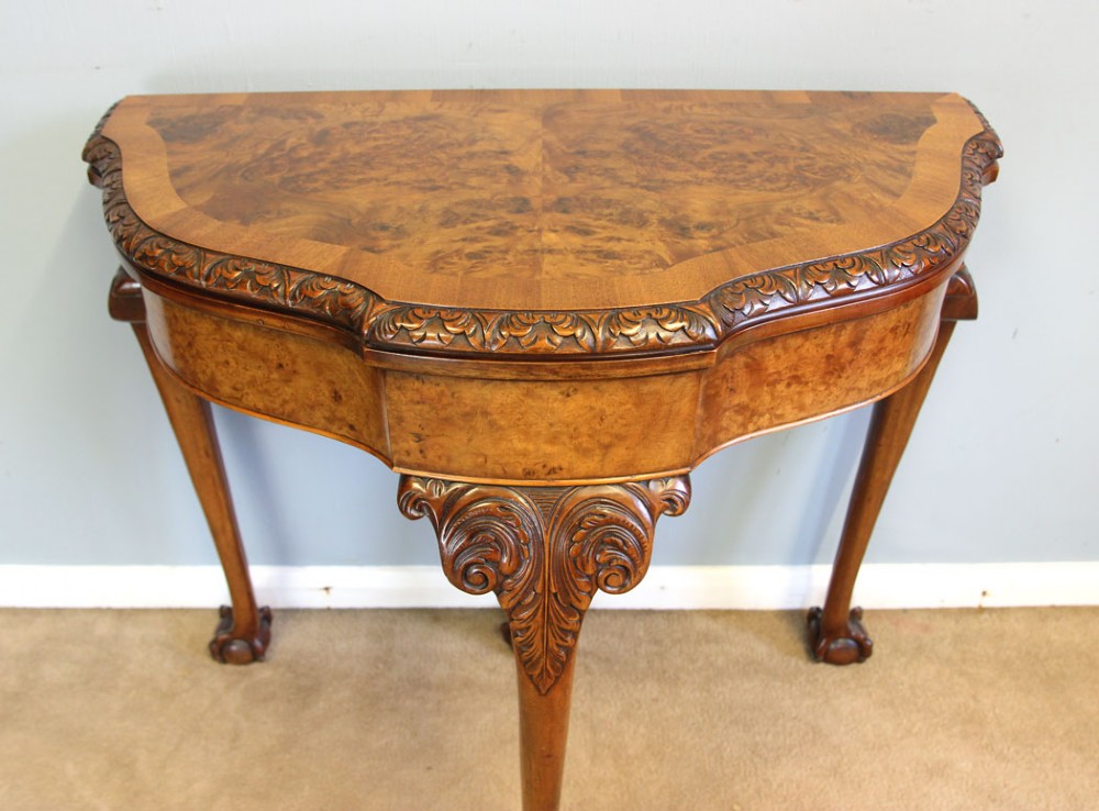 A demi-lune burr walnut fold-over card table featuring carved edges, cabriole legs, and carved ball-and-claw feet. View XII