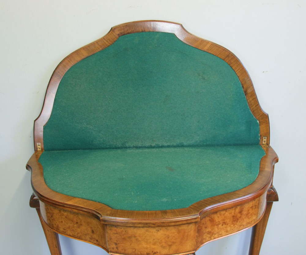 A demi-lune burr walnut fold-over card table featuring carved edges, cabriole legs, and carved ball-and-claw feet. View XIII