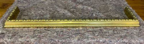 fig 1. A low rectangular Victorian brass fireplace fender featuring raised beaded moulding and a polished golden finish.