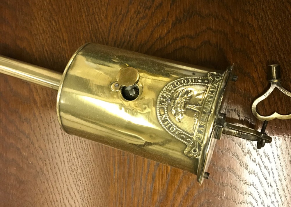 A cylindrical Georgian brass bottle spit jack featuring an embossed maker crest and a long top neck. View III