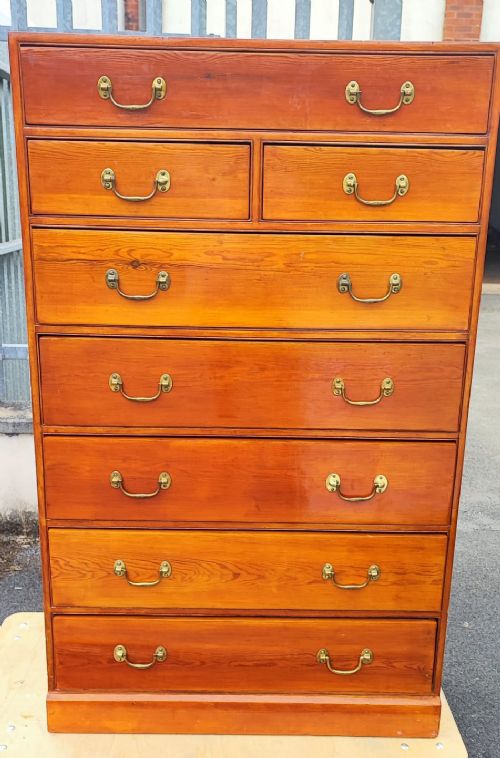 AN ANTIQUE TALL PINE CHEST OF DRAWERS
