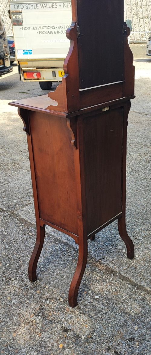 A narrow Victorian mahogany standing dressing table featuring an integrated swivel mirror above a single drawer, storage cupboard, and curved legs. View II
