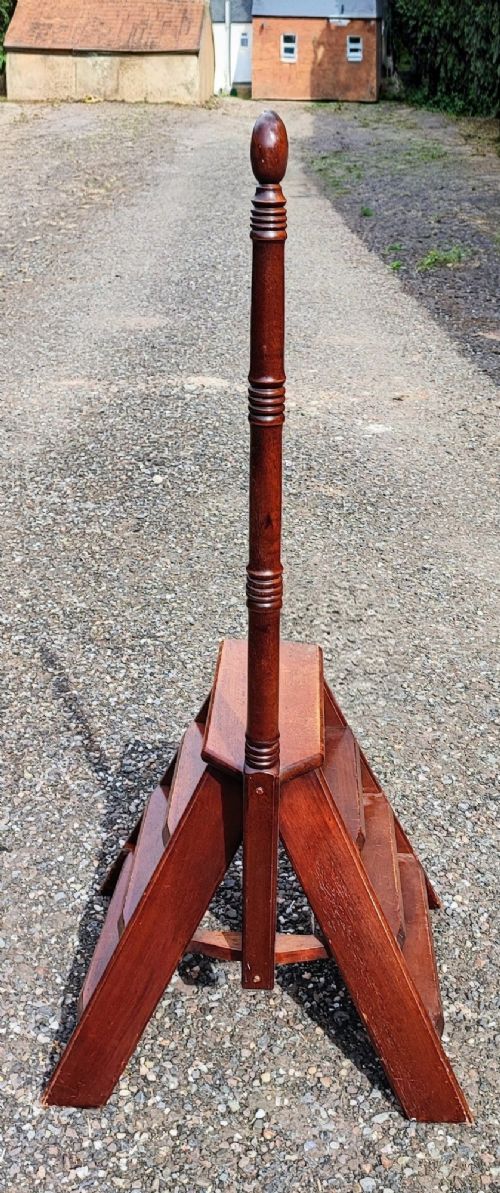 A set of wooden mahogany library steps featuring three treads, an A-frame support structure, and a tall turned wooden pole topped with a finial. View III