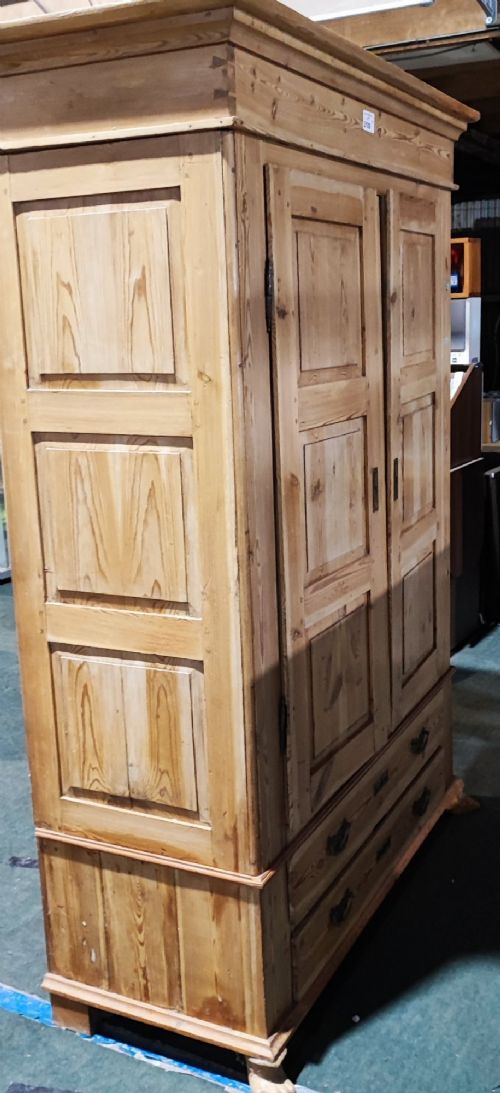 A tall antique pine two-door wardrobe featuring raised fielded panels, a moulded cornice, and two drawers at the base. View VIII