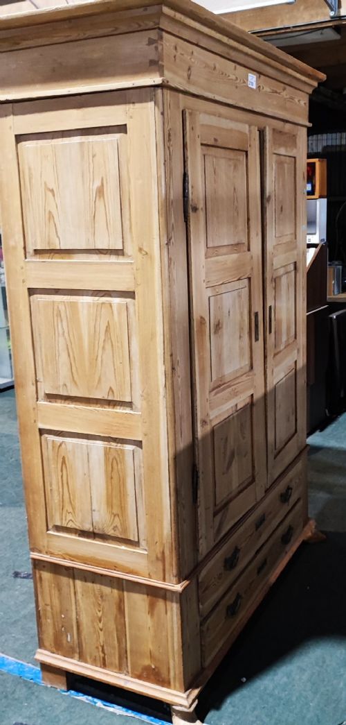 A tall antique pine two-door wardrobe featuring raised fielded panels, a moulded cornice, and two drawers at the base. View IX