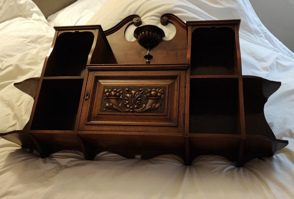 An antique mahogany hanging wall shelf with cabinet.
