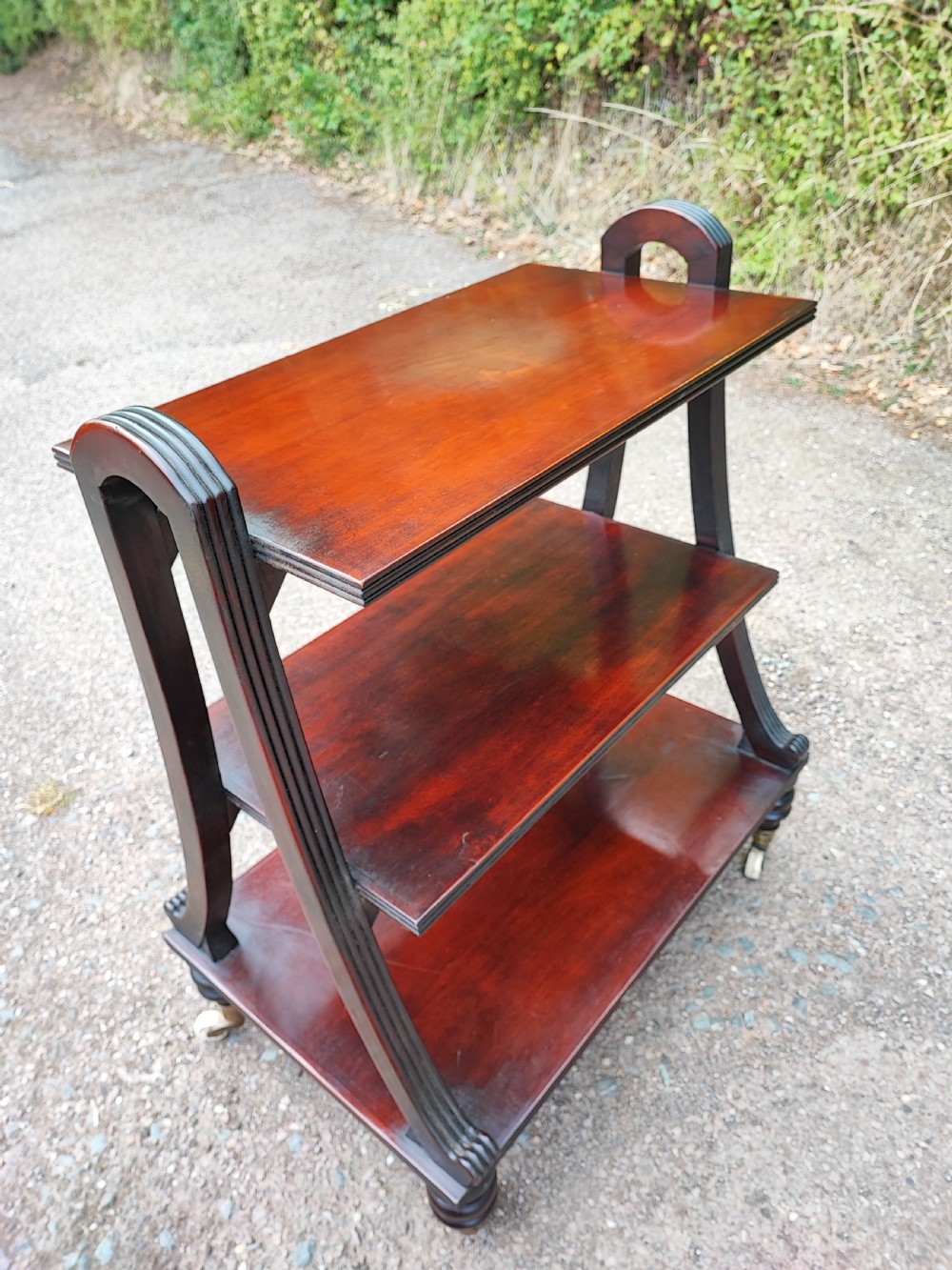 An antique free standing open bookcase in the Regency style. 