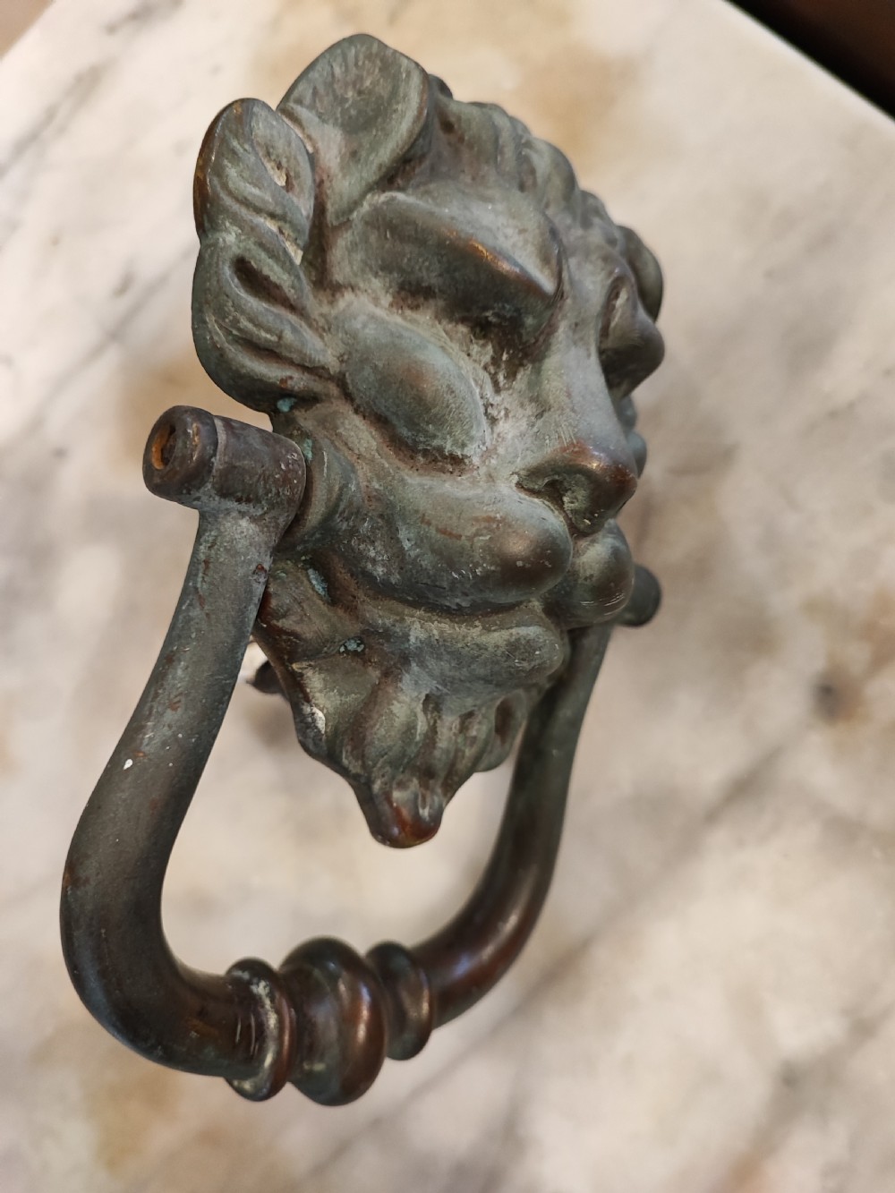 A Regency bronze lion head door knocker. In original condition. View III