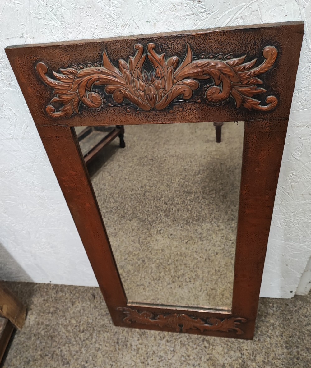 An antique arts and crafts copper framed mirror.