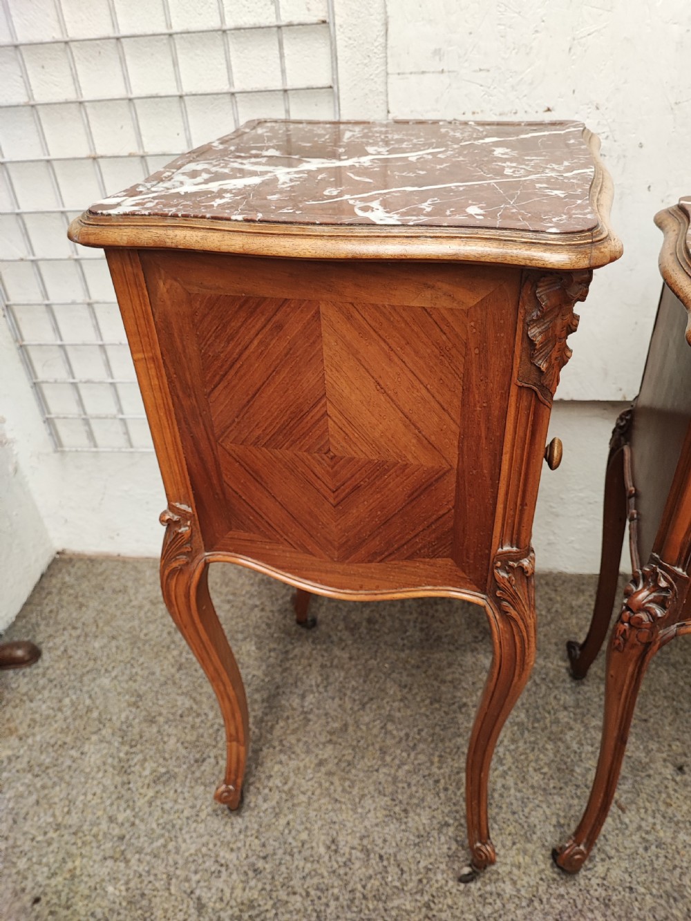 An antique matched pair of French marble top bedside cabinets.  View II