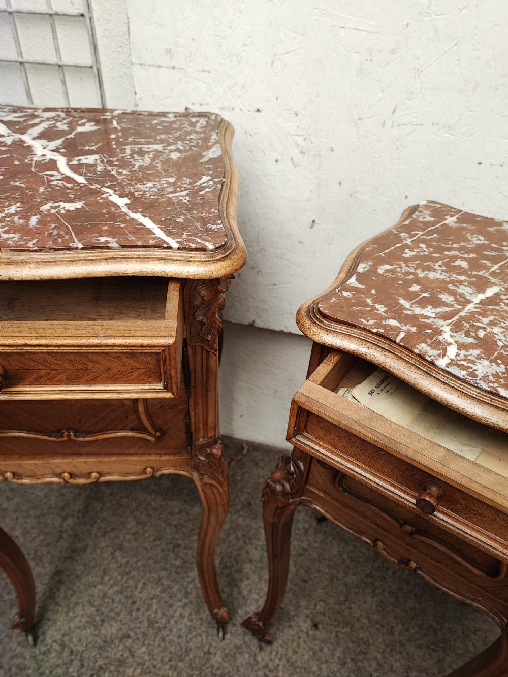 An antique matched pair of French marble top bedside cabinets.  View IV