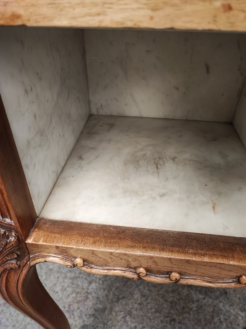 An antique matched pair of French marble top bedside cabinets.  View VI
